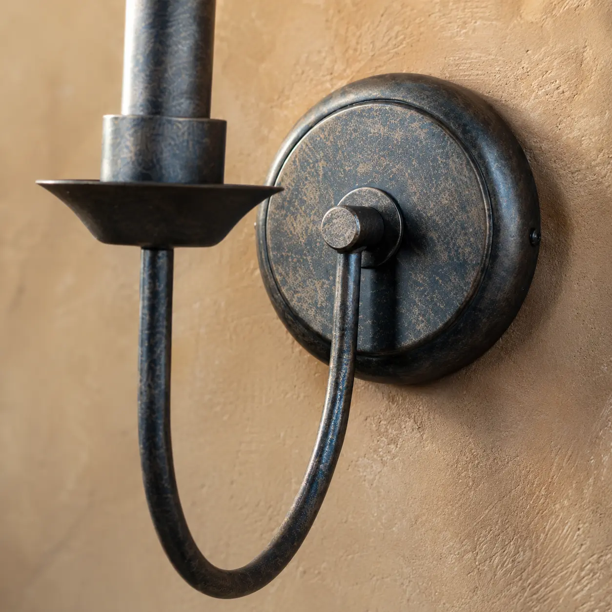 Close view of antique metal backplate and curved arm