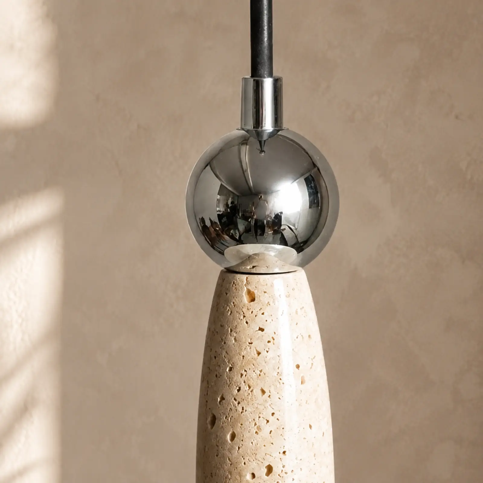 Polished metal sphere and suspension cord connection