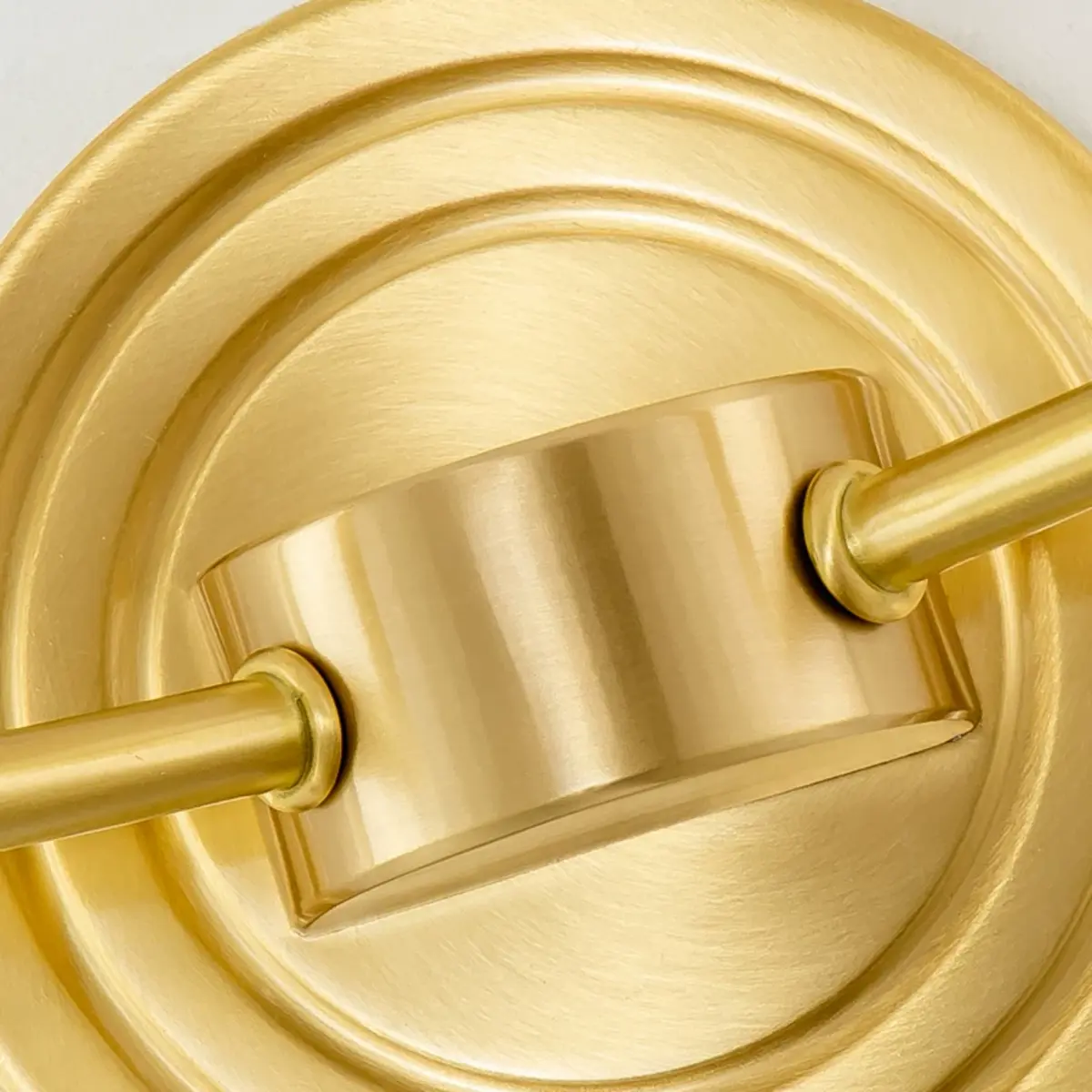 Close view of the brushed antique-brass backplate and arm connections