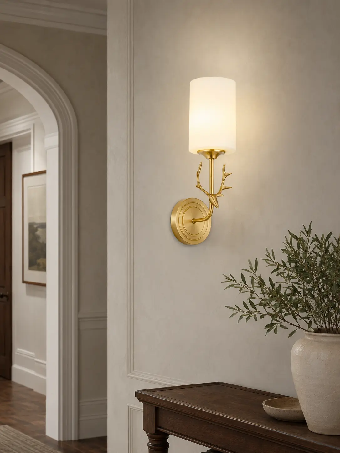 Single-light antler wall sconce in a warm American entry hallway